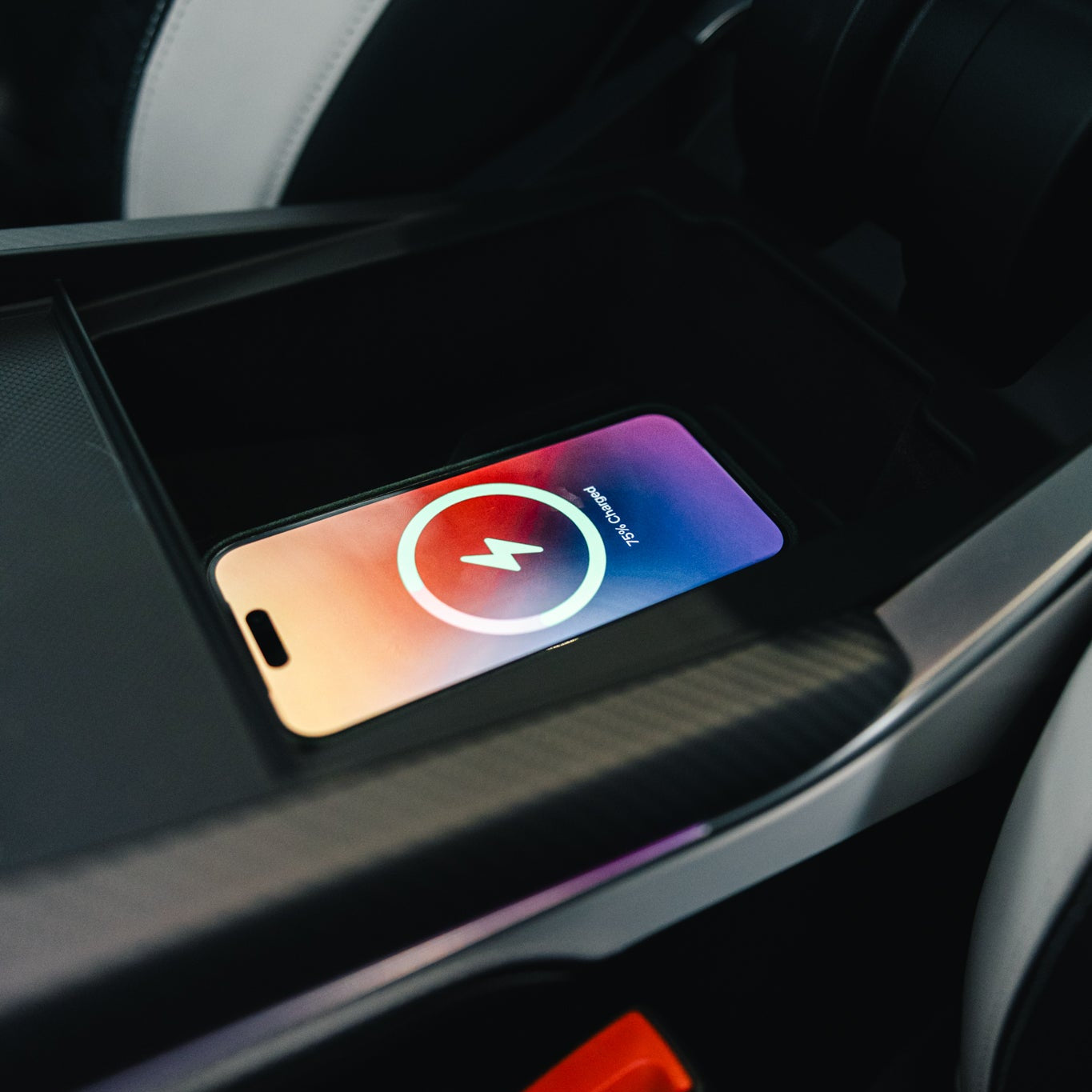 Phone with a charging icon on a car dashboard
